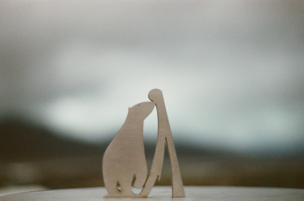 A metal sculpture showing a polar bear and an artistic mountain is in focus in the middle of the image. 