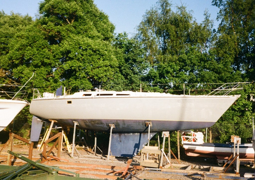 A view of the whole boat from the side in its cradle shows the hull painted grey with primer. 