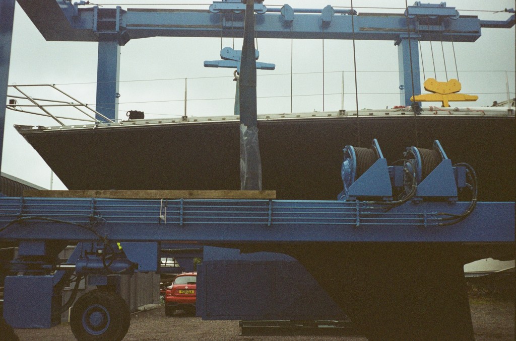 A side view of a boat in a sling and winch system is seen. 