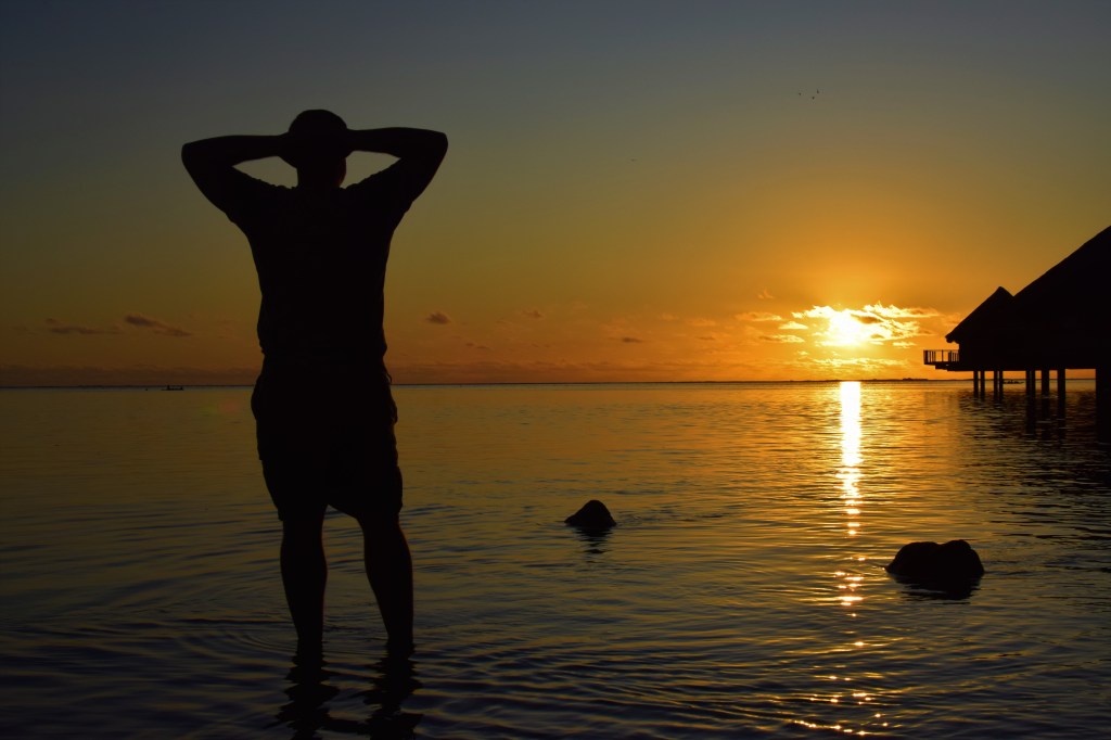 A man is silhouetted against a sunset. 