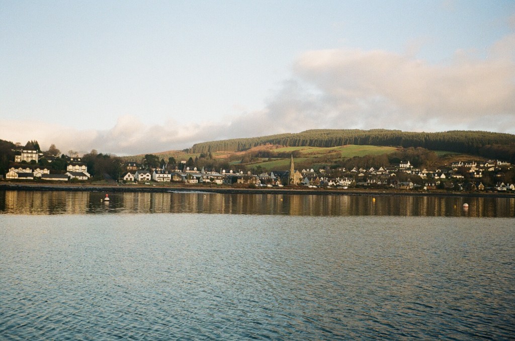 A seas side town is reflected in still waters. 